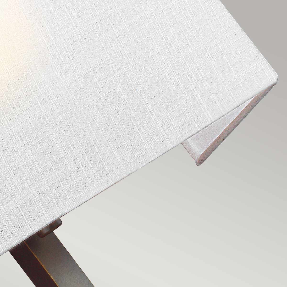 Gros plan sur la texture tissée de l'abat-jour blanc et sa couture d'angle
