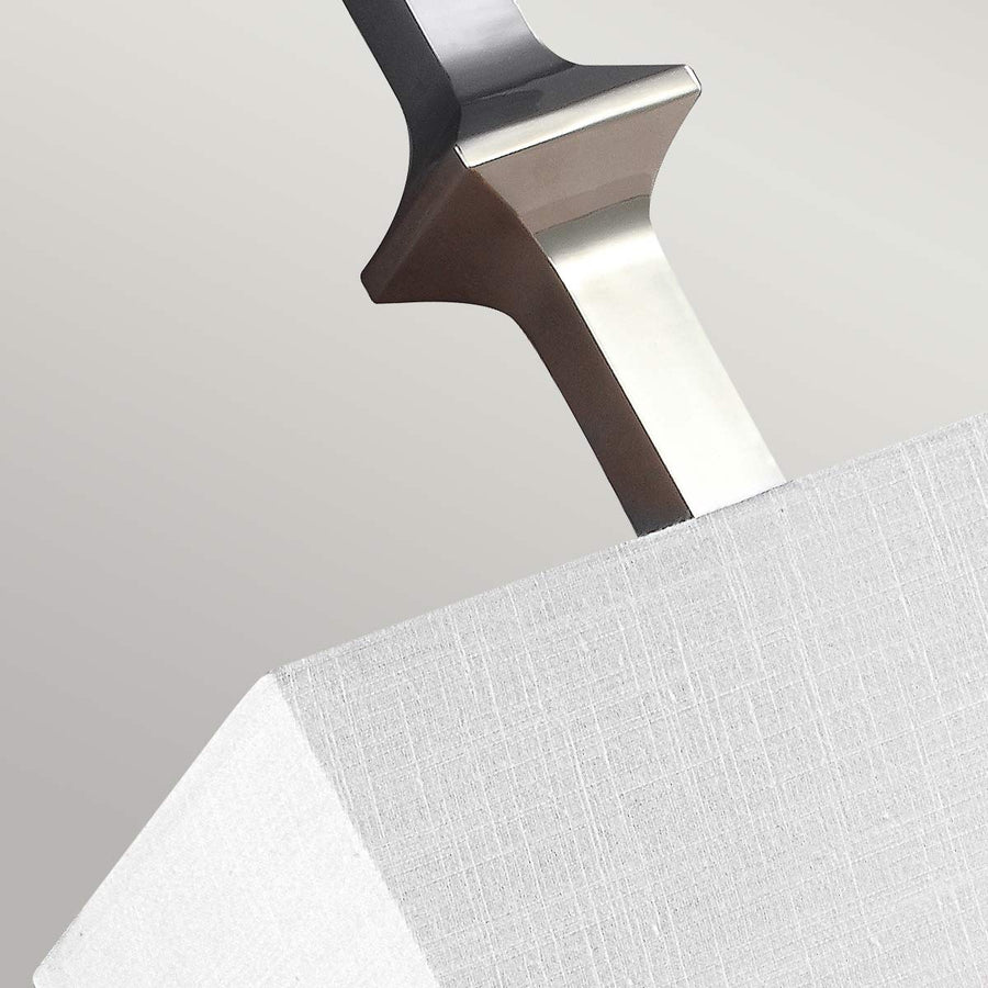 Gros plan sur l'élément décoratif en nickel au-dessus de l'abat-jour textile.