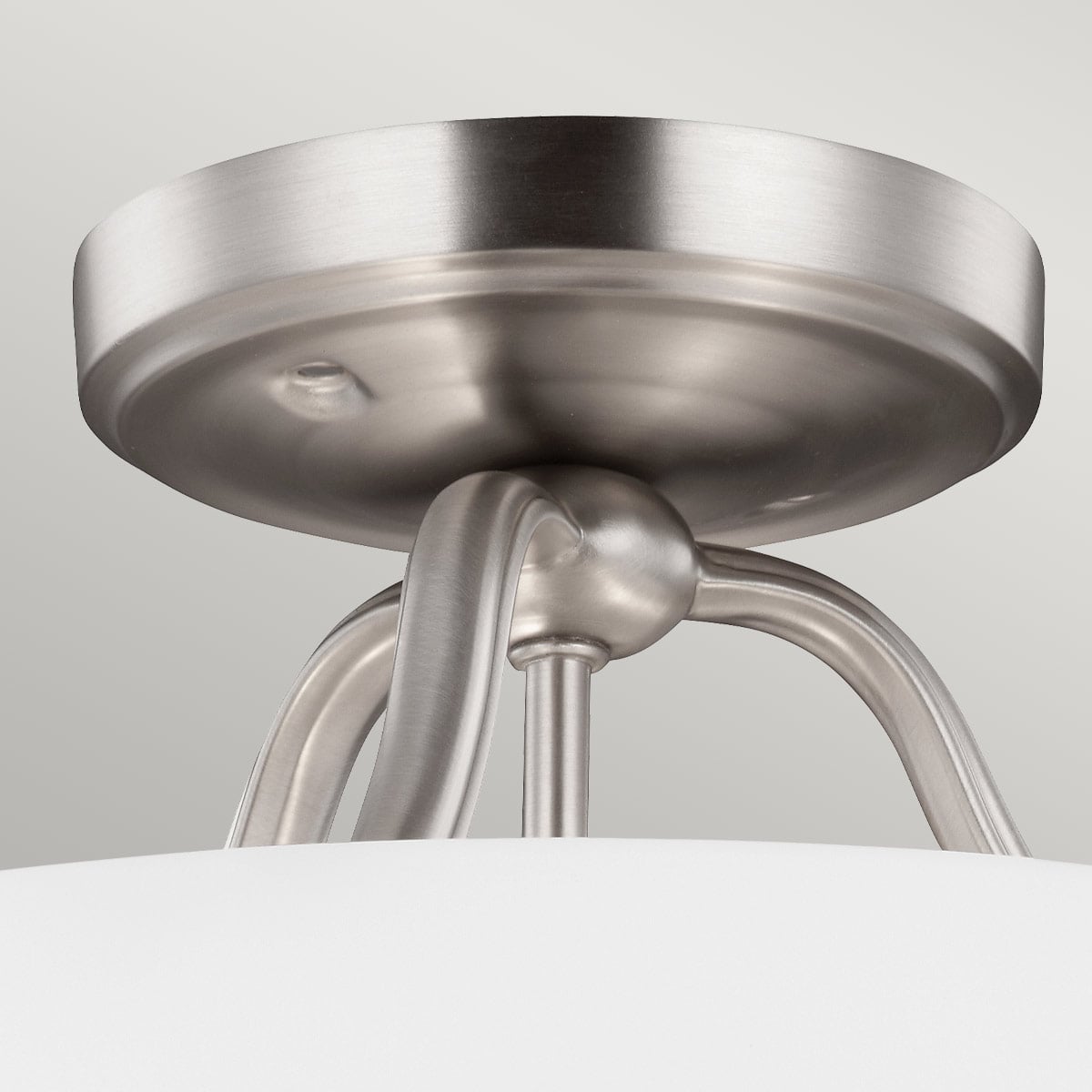 Détail de la fixation au plafond et des bras métalliques courbés en finition nickel