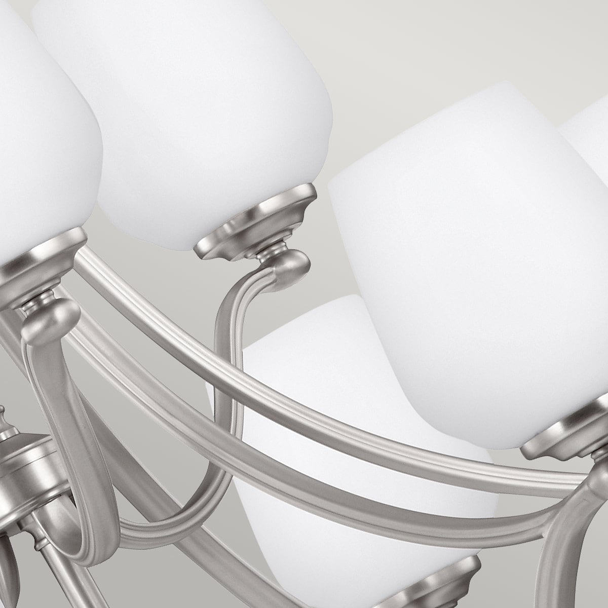 Détail des abat-jours en verre blanc et des bras incurvés en nickel brossé