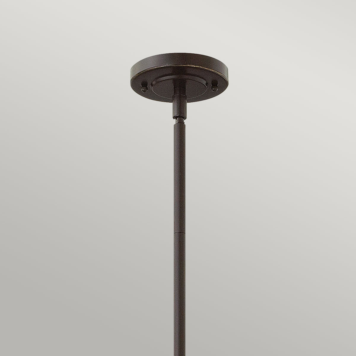 Détail du cache-piton rond en bronze fixé au plafond, avec sa tige filetée