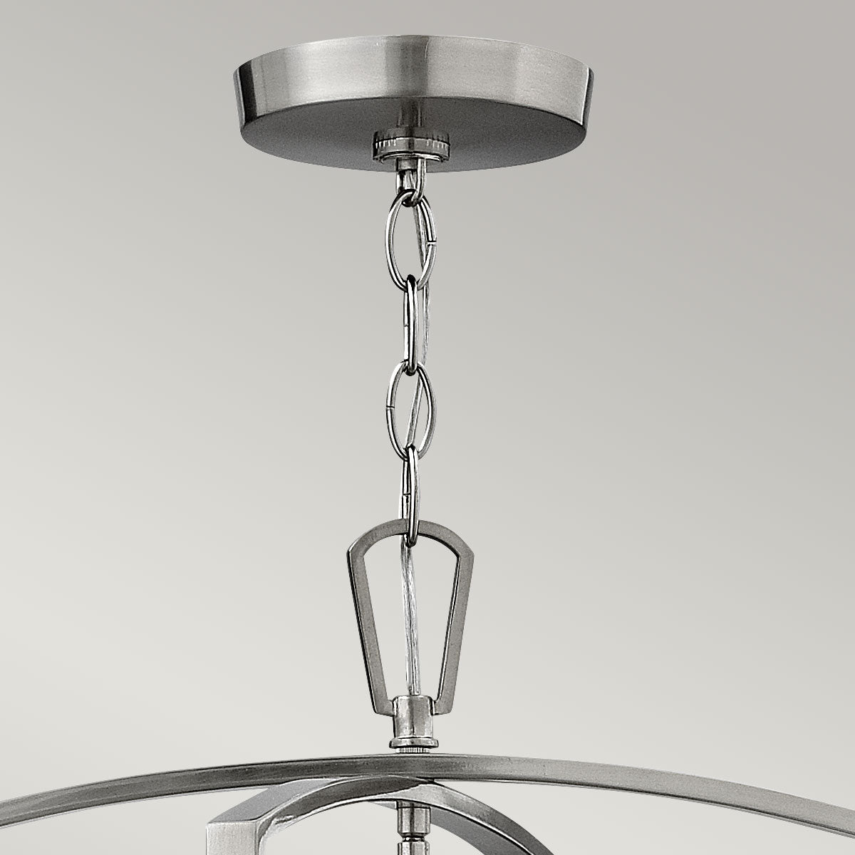 Gros plan sur la platine de plafond et la chaîne en nickel satiné de la suspension.