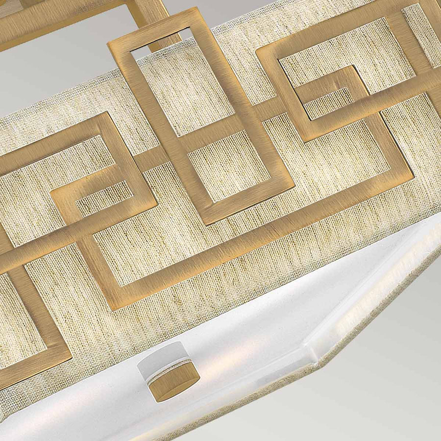 Détail du motif géométrique doré et du diffuseur blanc inférieur