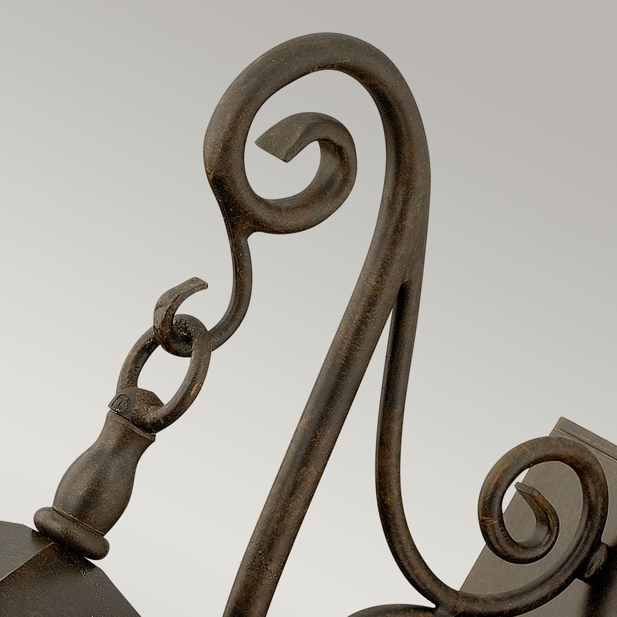 Détail de la volute supérieure et de l'attache suspendue en métal bronze.