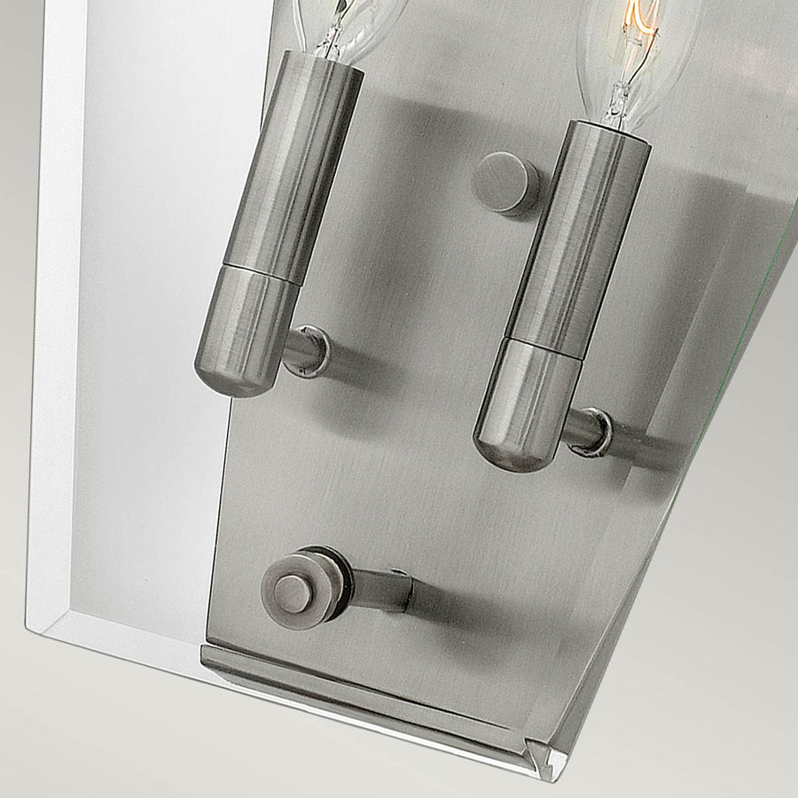 Vue rapprochée du bas, bras de fixation nickel et douilles cylindriques soutenant les ampoules.