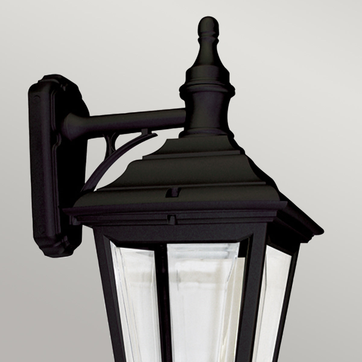 Gros plan sur le support mural et le haut du luminaire extérieur noir