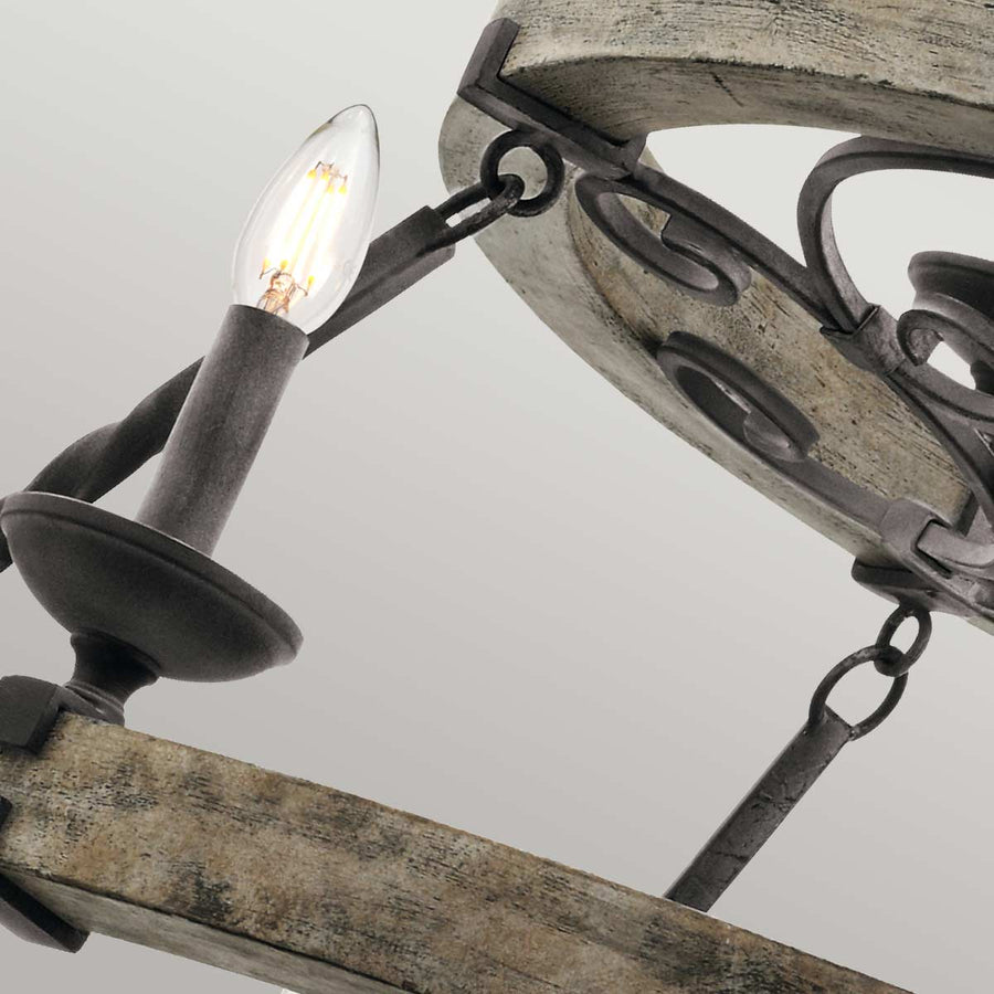 Vue rapprochée d'une ampoule et de l'armature en métal reliant les cercles de bois.