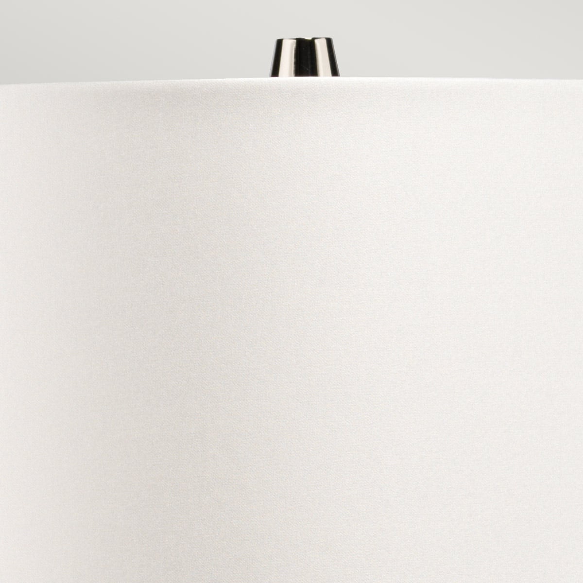 Détail du sommet de l'abat-jour blanc et de son finial chromé