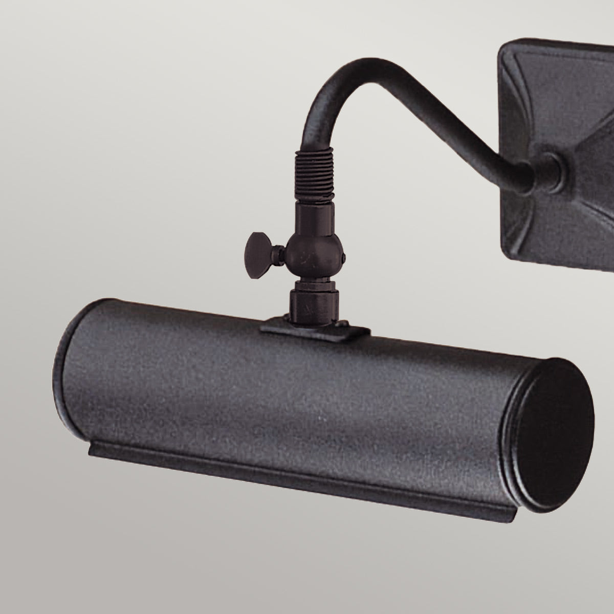 Gros plan sur l'articulation moletée et l'abat-jour cylindrique noir.