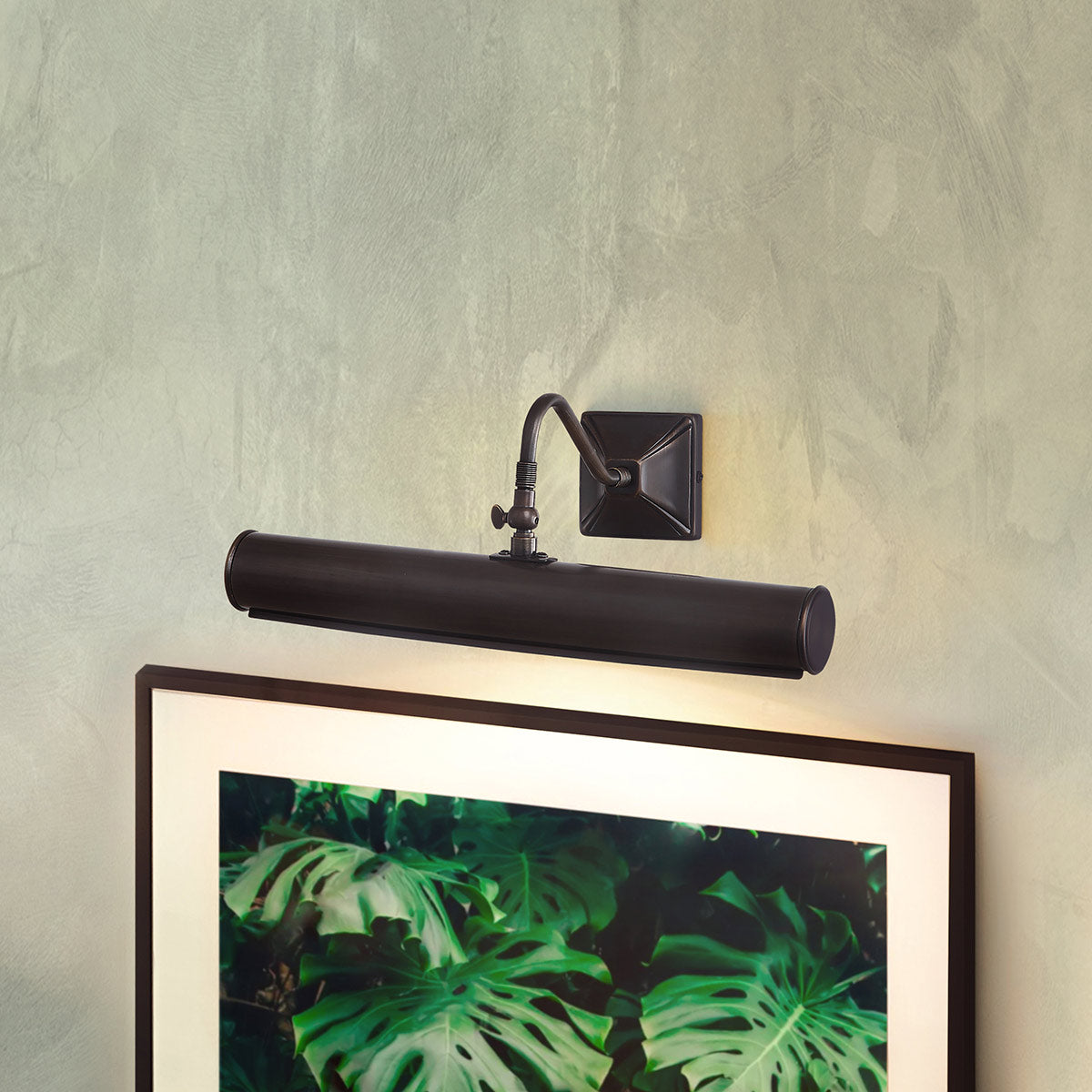 Mise en ambiance : applique fixée au mur au-dessus d'un tableau encadré