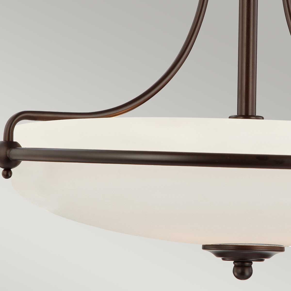 Vue rapprochée des bras courbes et du cabochon en bronze patiné