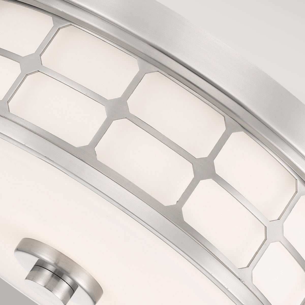 Détail rapproché de la grille métallique et du verre blanc translucide.