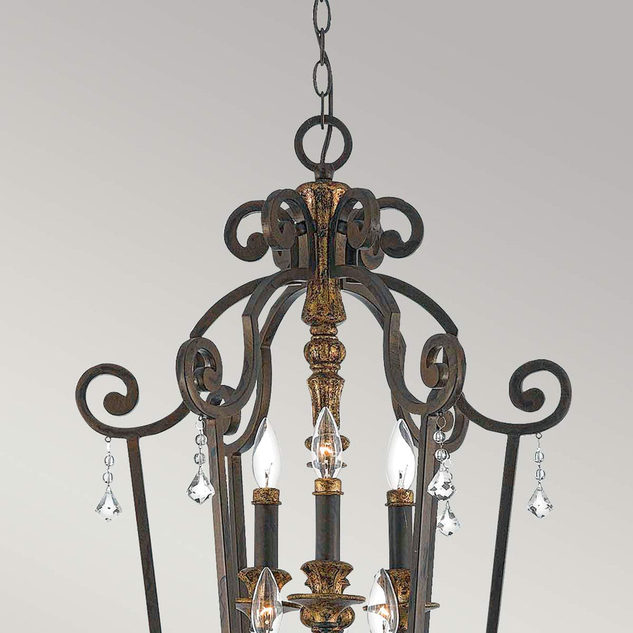 Détail du sommet avec chaîne, volutes en fer doré et cristaux taillés.