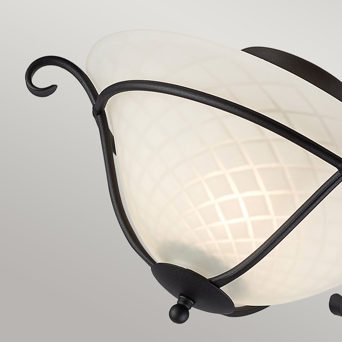 Détail de l'enroulement décoratif en fer forgé et du cabochon inférieur