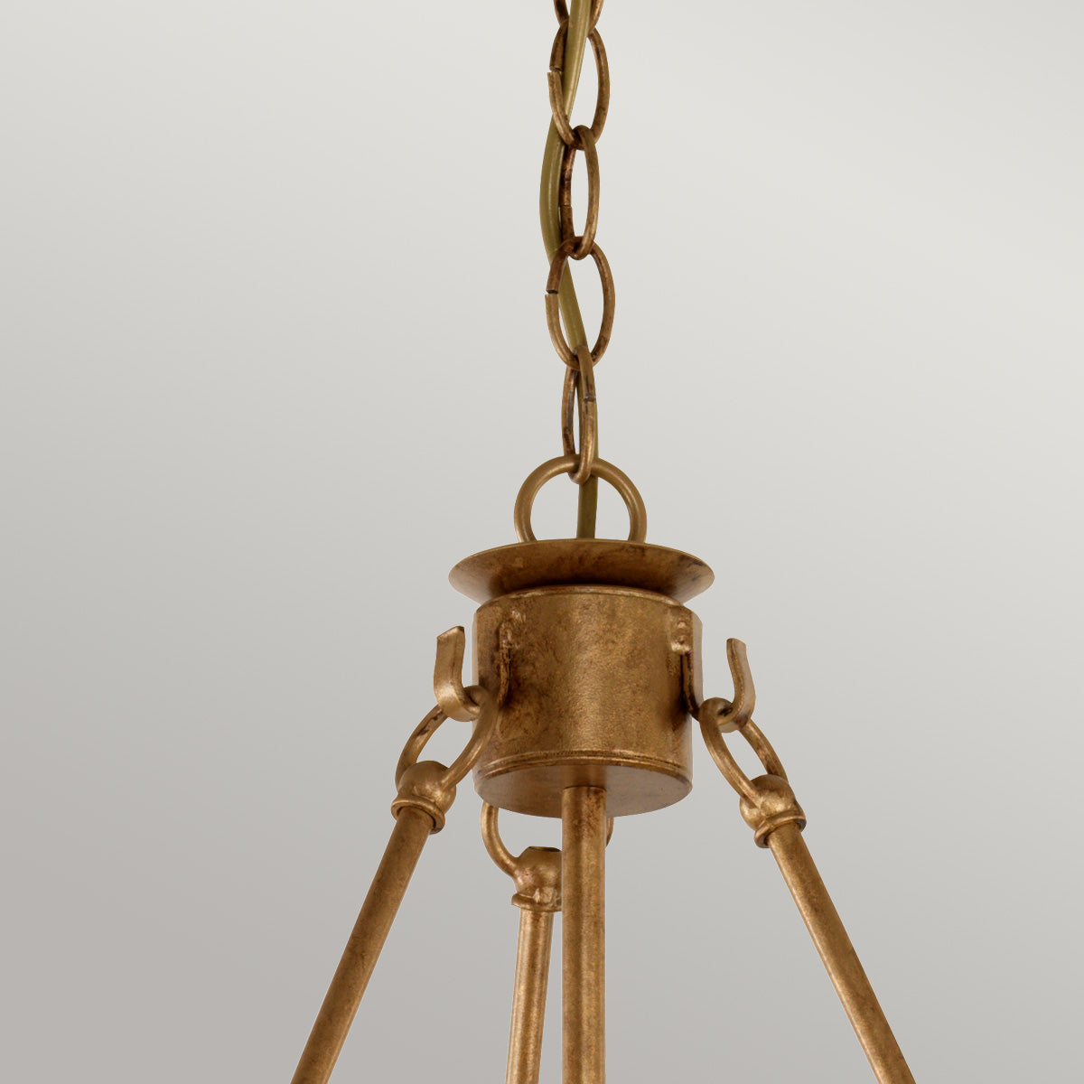 Détail du sommet : chaîne, anneau et fixation du lustre doré au plafond.