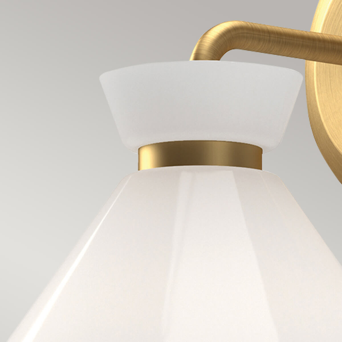 Gros plan sur le verre opalin et la bague en laiton doré du luminaire
