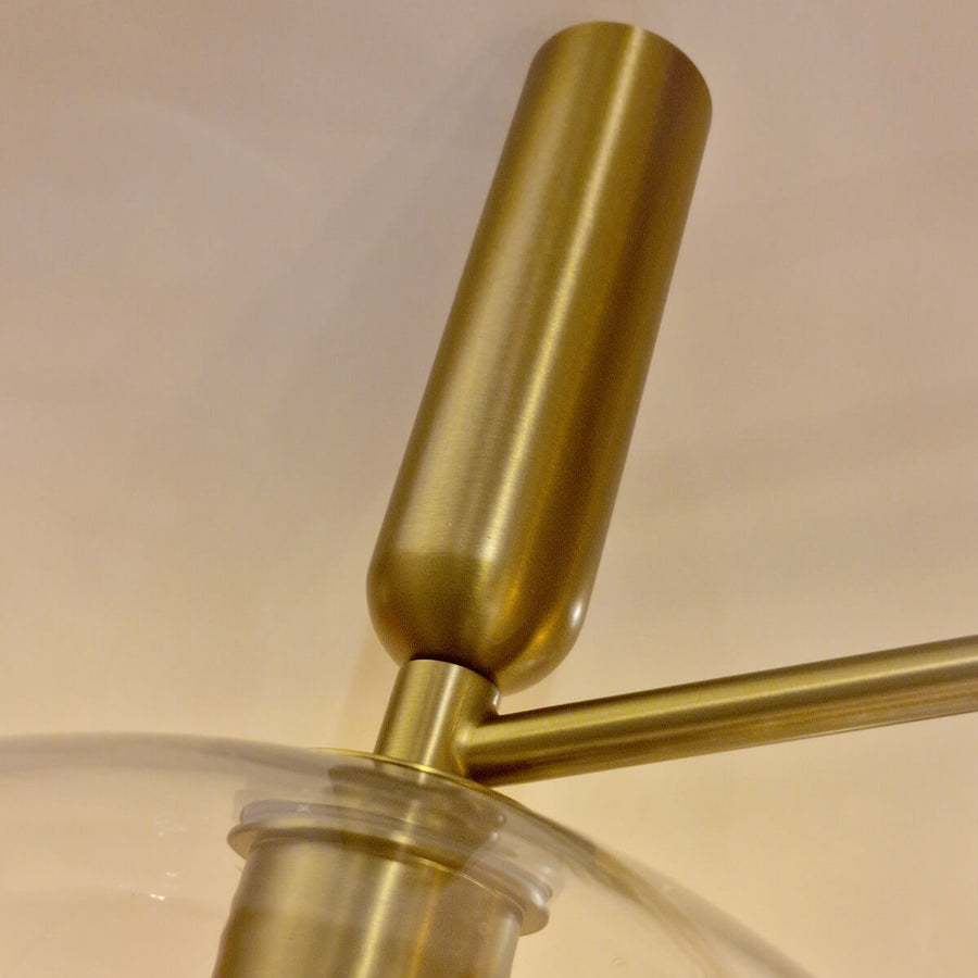 Détail d'un bras cylindrique en métal doré brossé et de son raccord