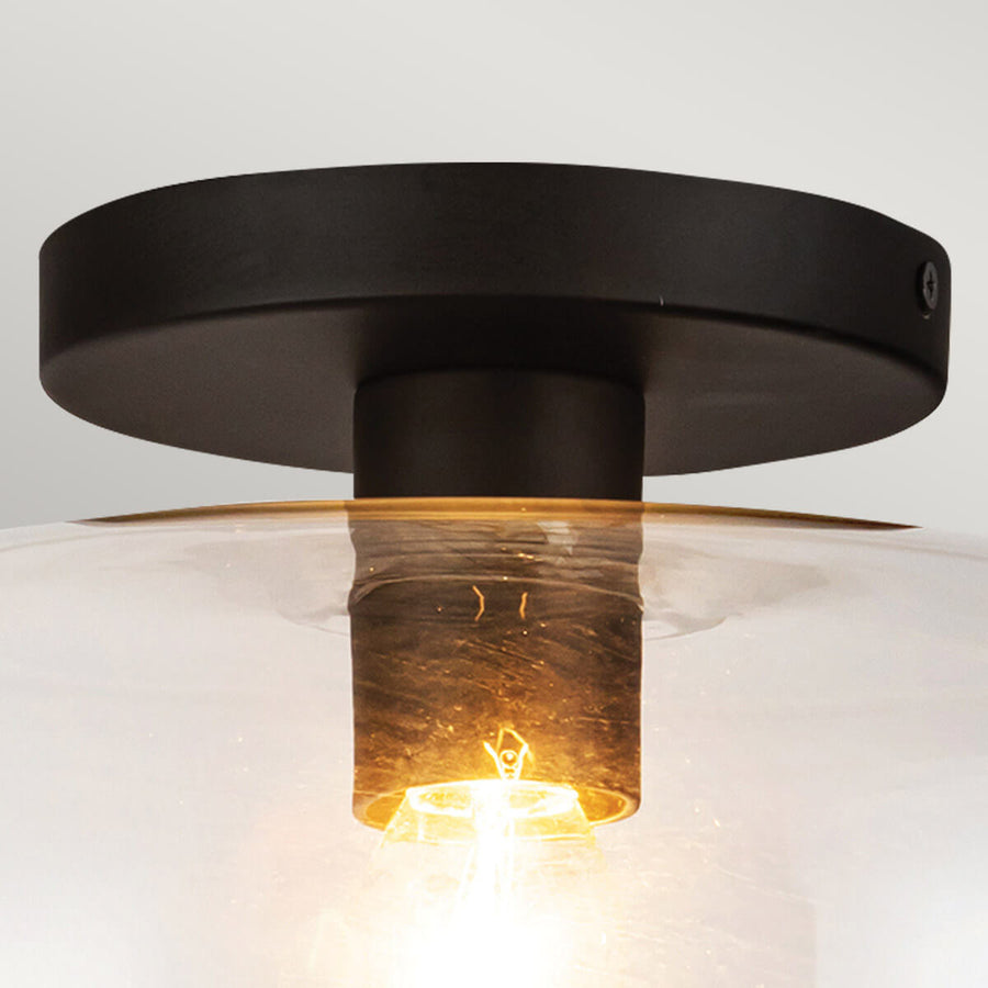 Détail du support noir mat fixé au plafond et du col en verre teinté