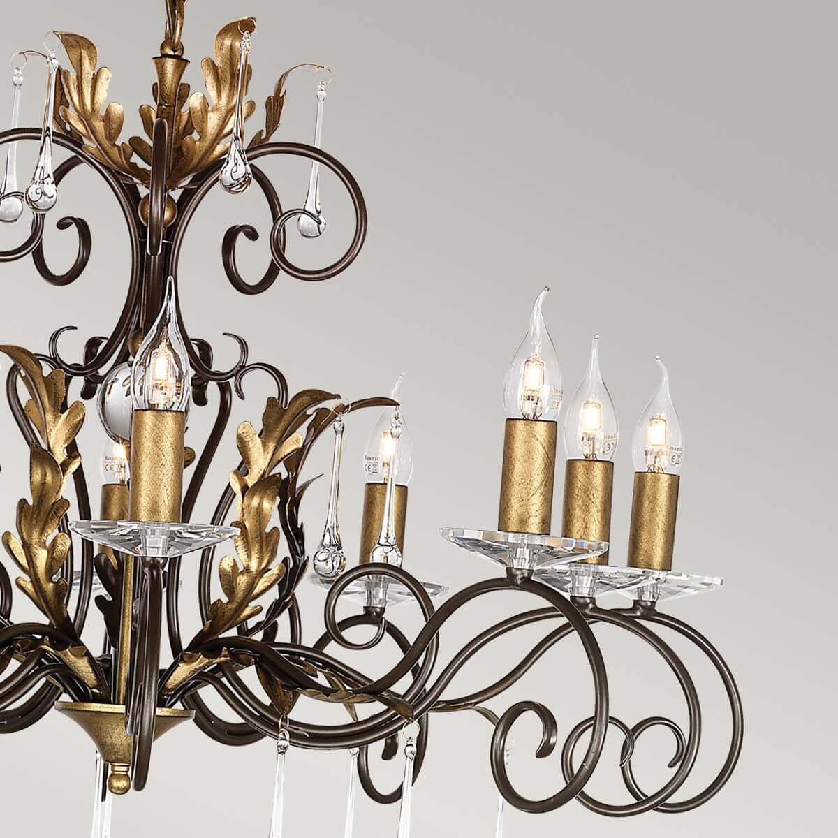 Vue rapprochée des bougies dorées, ampoules flamme et gouttes de cristal suspendues