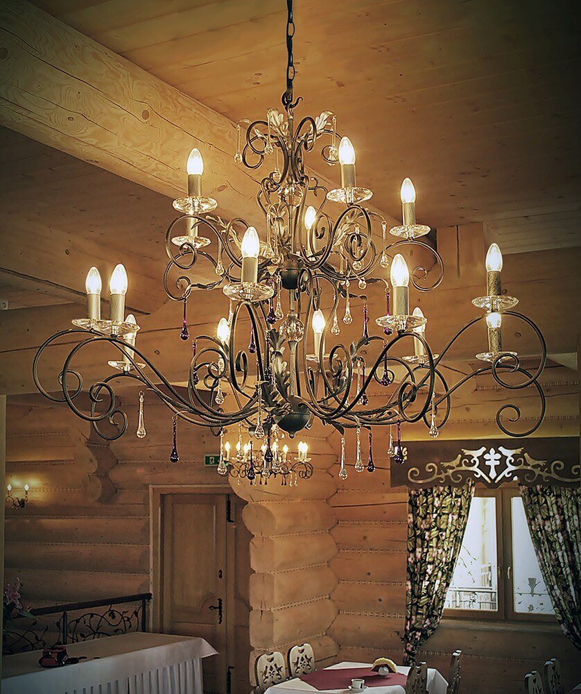 Lustre suspendu au plafond en bois dans une salle chaleureuse, allumé, montrant son échelle réelle.