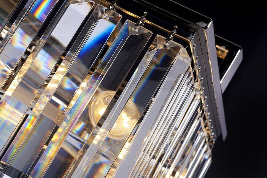 Gros plan sur les prismes de cristal irisés et l'ampoule allumée à l'intérieur