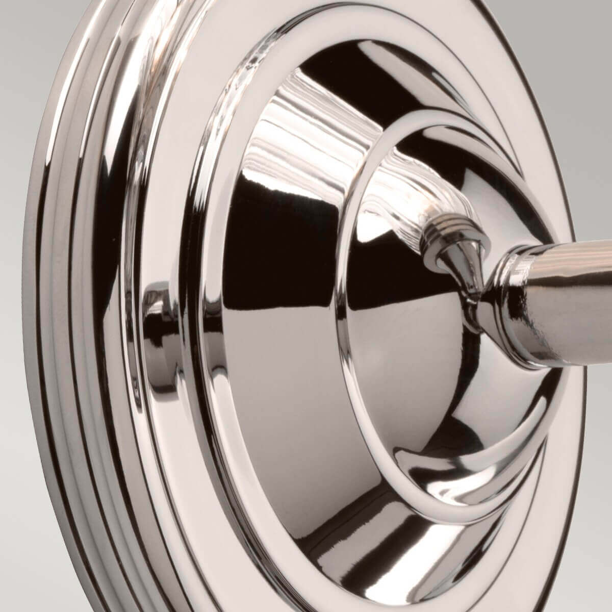 Gros plan sur la rosace ronde et le bras en nickel poli effet miroir