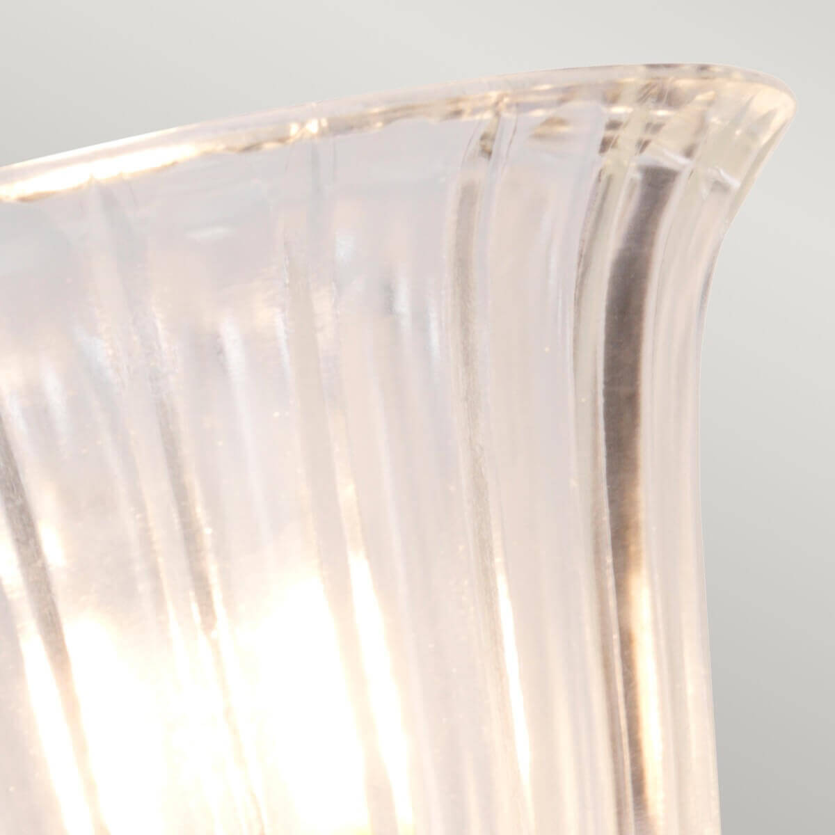 Détail du bord évasé du verre transparent laissant voir l'ampoule allumée