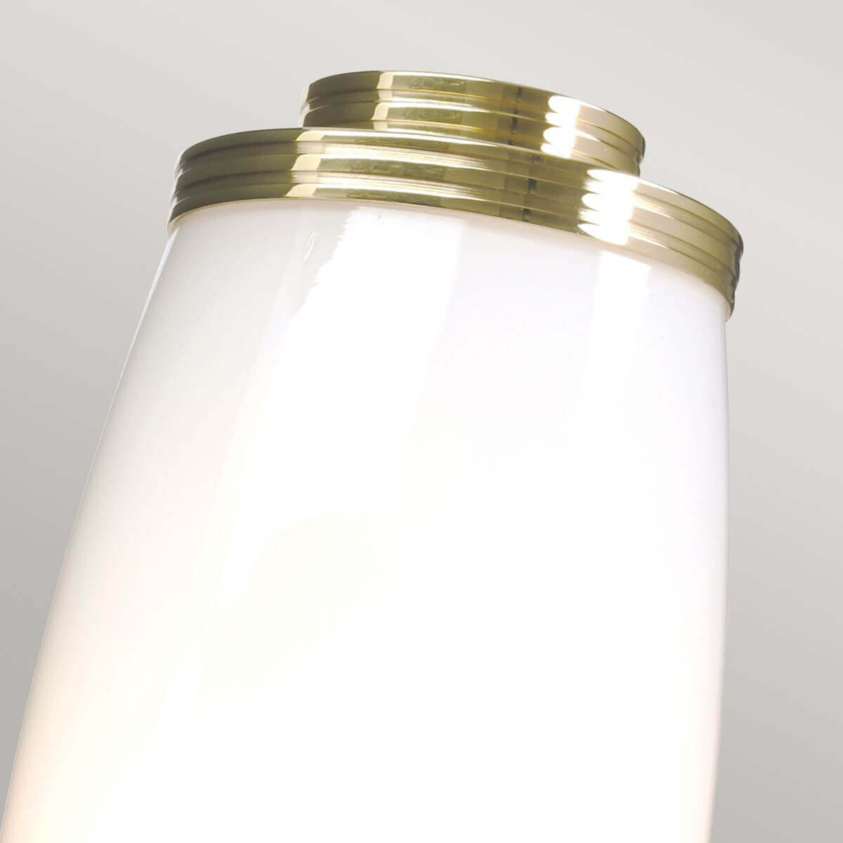 Vue rapprochée du sommet du verre opalin serti dans le laiton poli