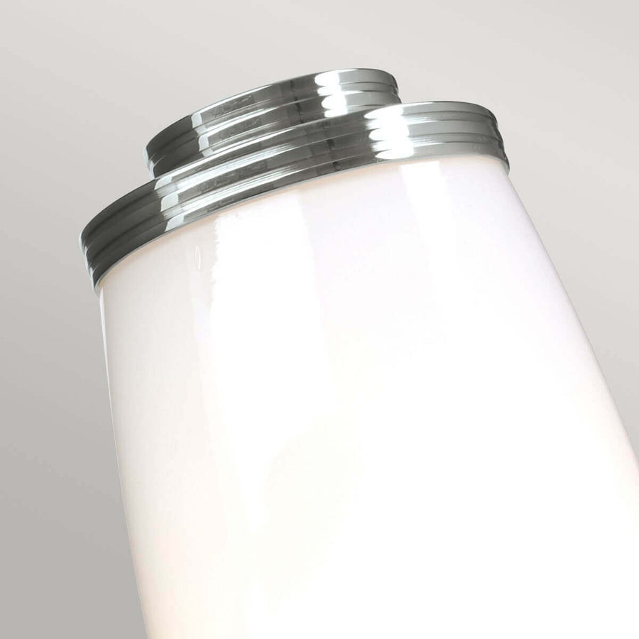 Gros plan du col strié chromé coiffant le haut du diffuseur en verre blanc