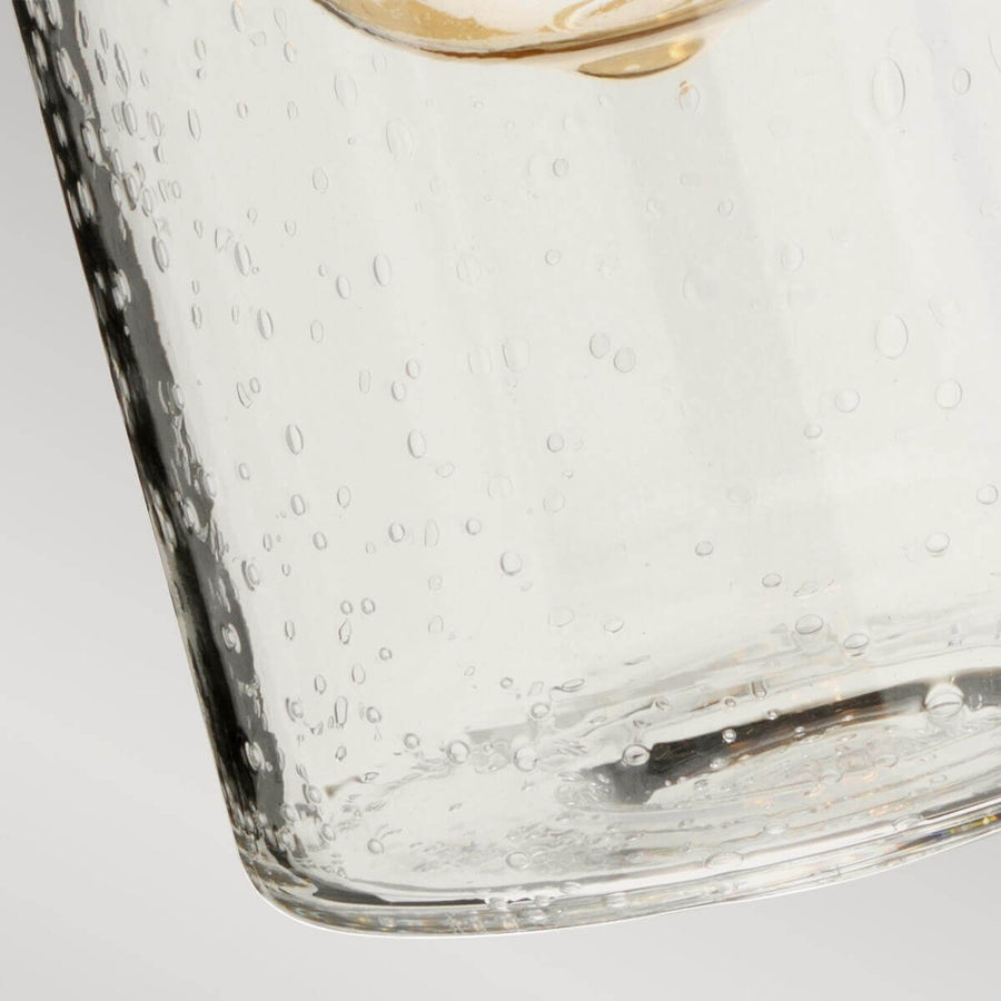 Détail du bas du cylindre en verre bullé aux reflets brillants