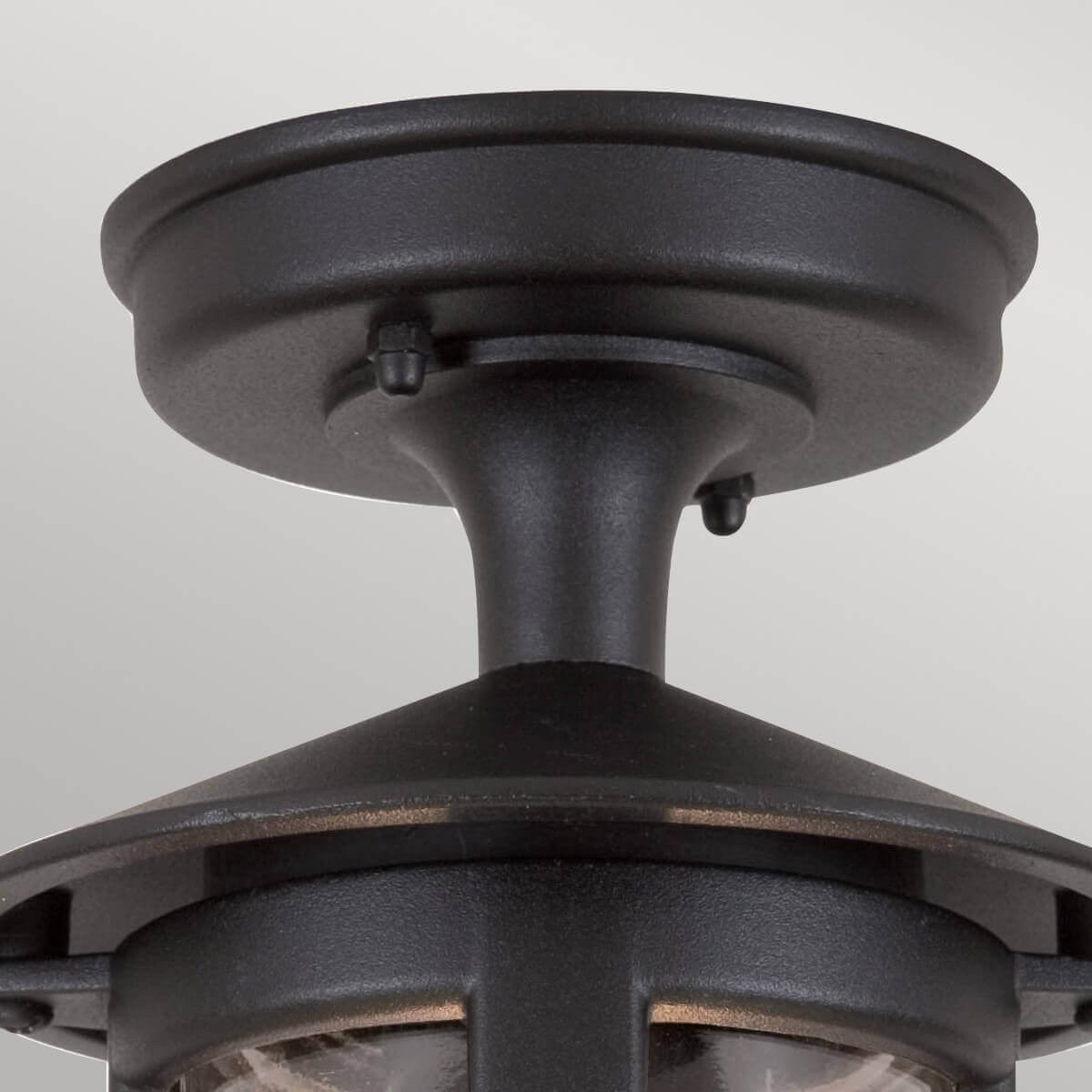 Détail de la fixation au plafond et du col métallique noir texturé
