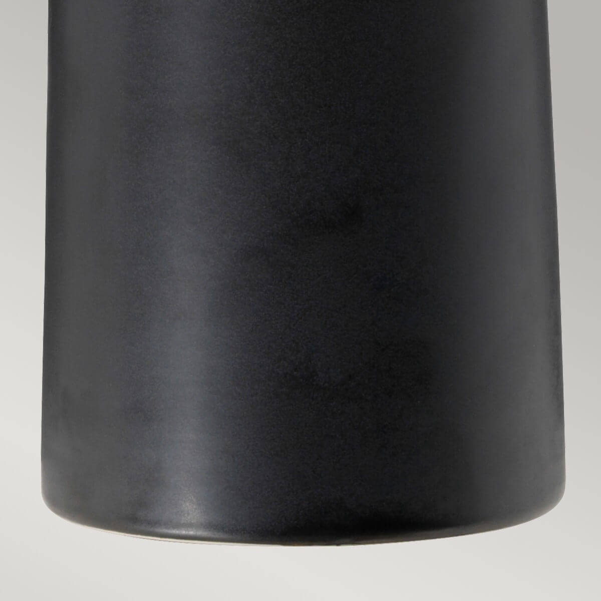 Détail du bas du pied en céramique noire mate, aspect lisse et légèrement velouté.