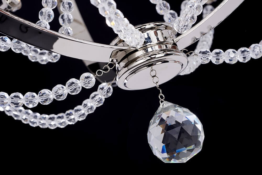 Gros plan sur le pendentif en cristal taillé et les chaînettes de perles transparentes