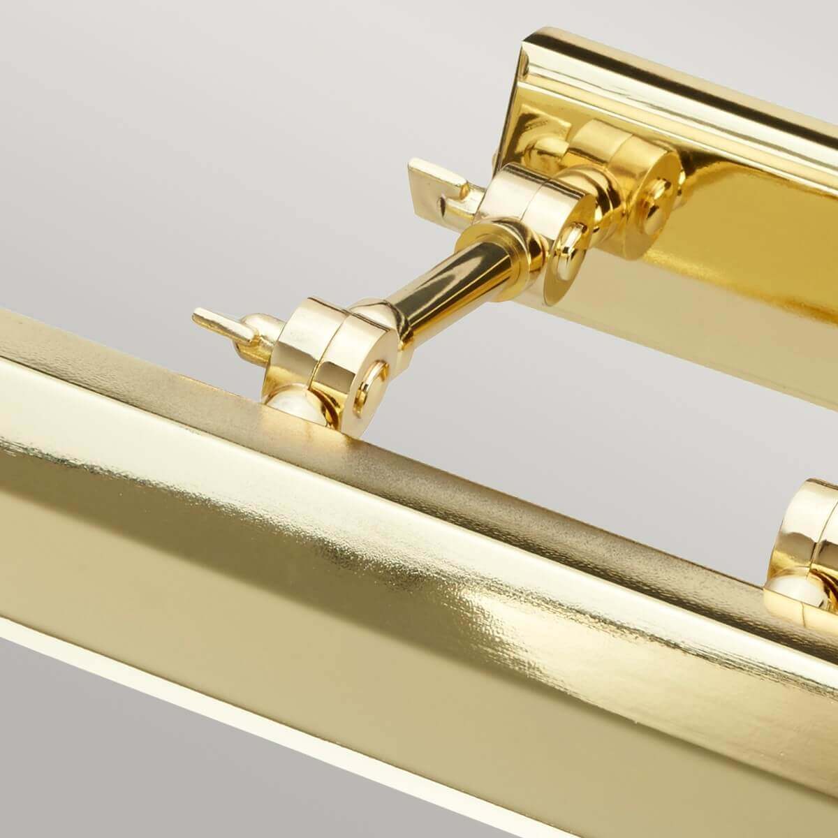 Détail rapproché des articulations métalliques et de la finition laiton poli brillant.