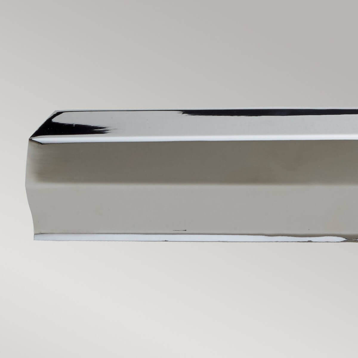 Gros plan sur l'extrémité du tube rectangulaire réfléchissant en nickel poli.