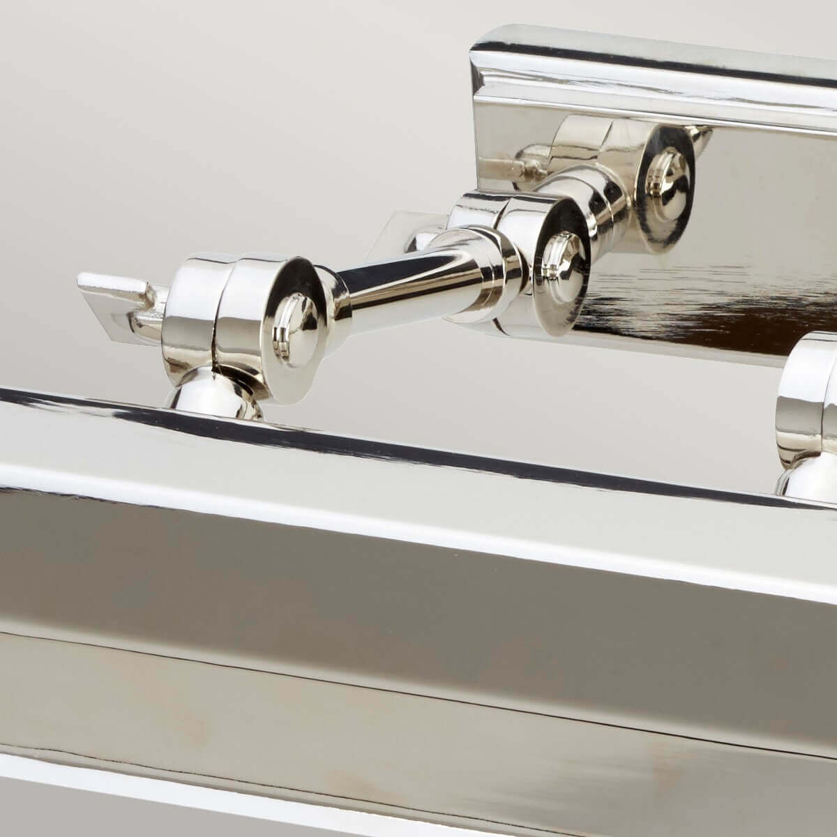 Détail des bras articulés et de la platine de fixation en nickel poli