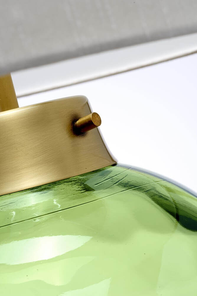 Détail du col en laiton brossé et du verre vert olive de la base.