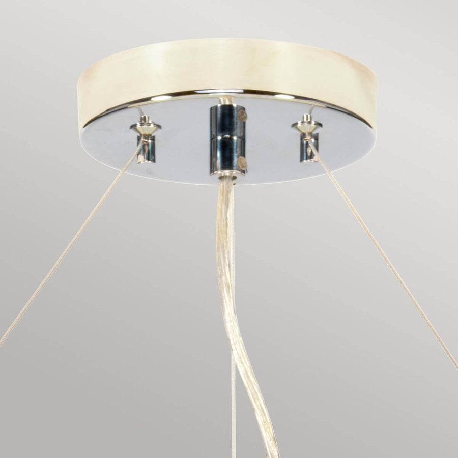 Détail du pavillon chromé fixé au plafond avec les trois câbles de suspension tendus