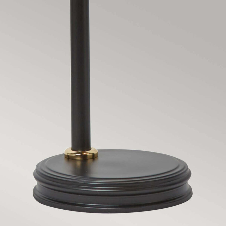 Détail de la base ronde noire avec bague dorée au pied