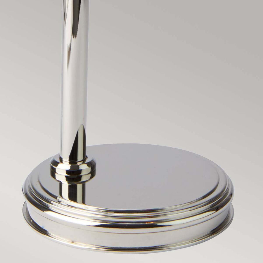 Détail de la base ronde et polie en nickel, avec la tige verticale fixée.