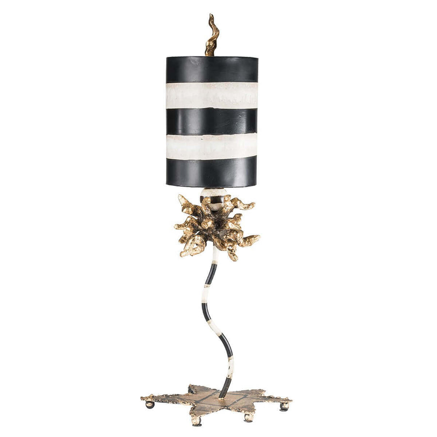 Lampe à poser sur fond blanc, abat-jour cylindrique rayé noir et blanc et base dorée
