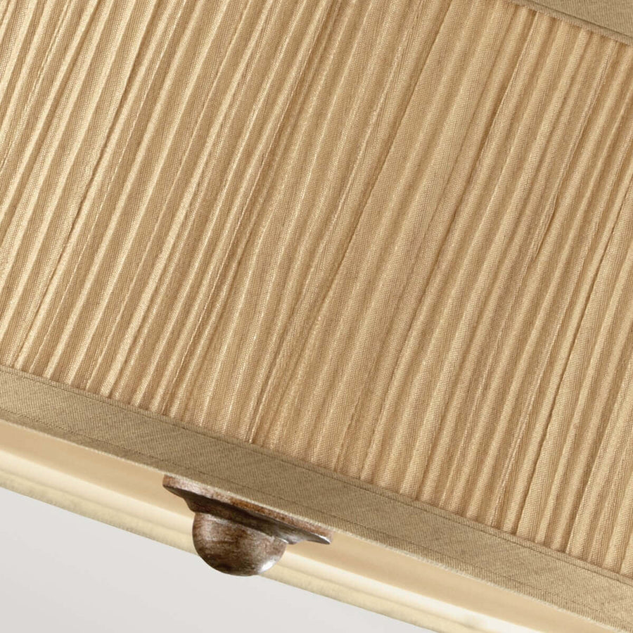 Détail du bas de l'abat-jour plissé beige et de la fixation centrale sombre