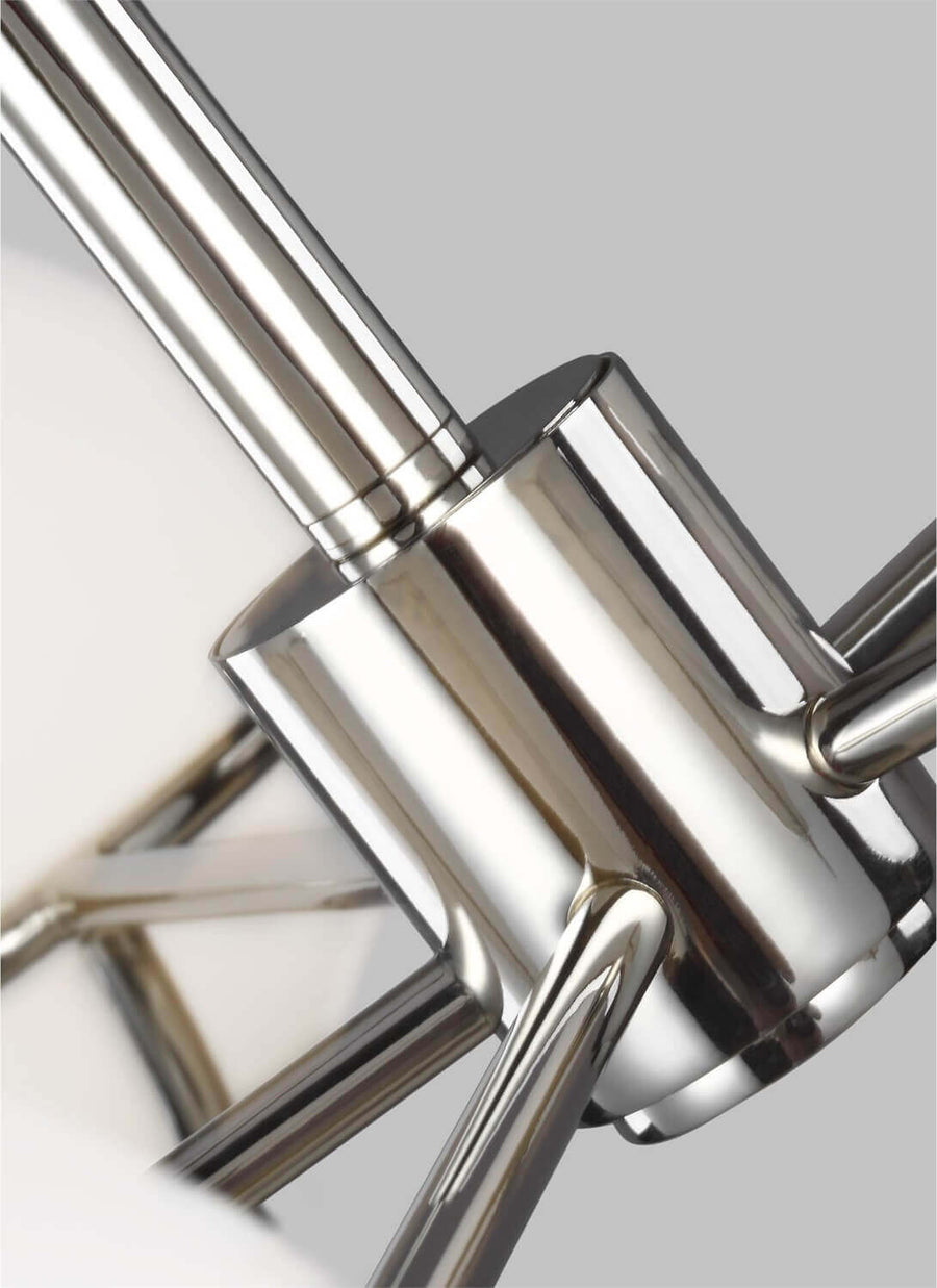 Détail du raccord cylindrique central en nickel poli et des bras reliant les globes