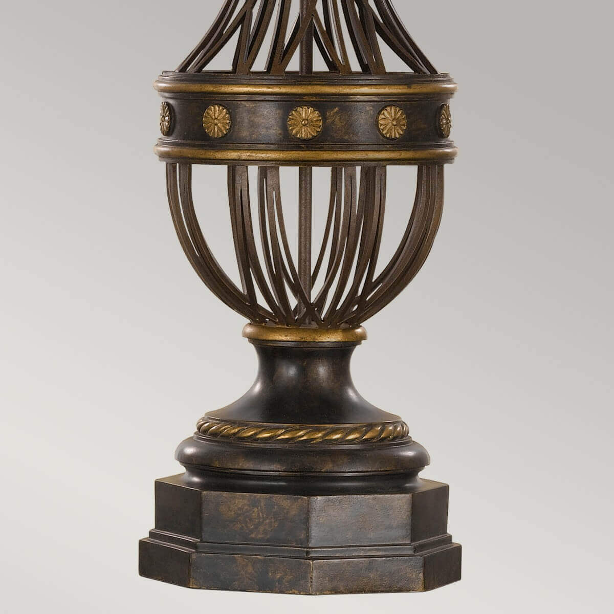 Détail de la base ajourée avec rosaces dorées et collerette torsadée.