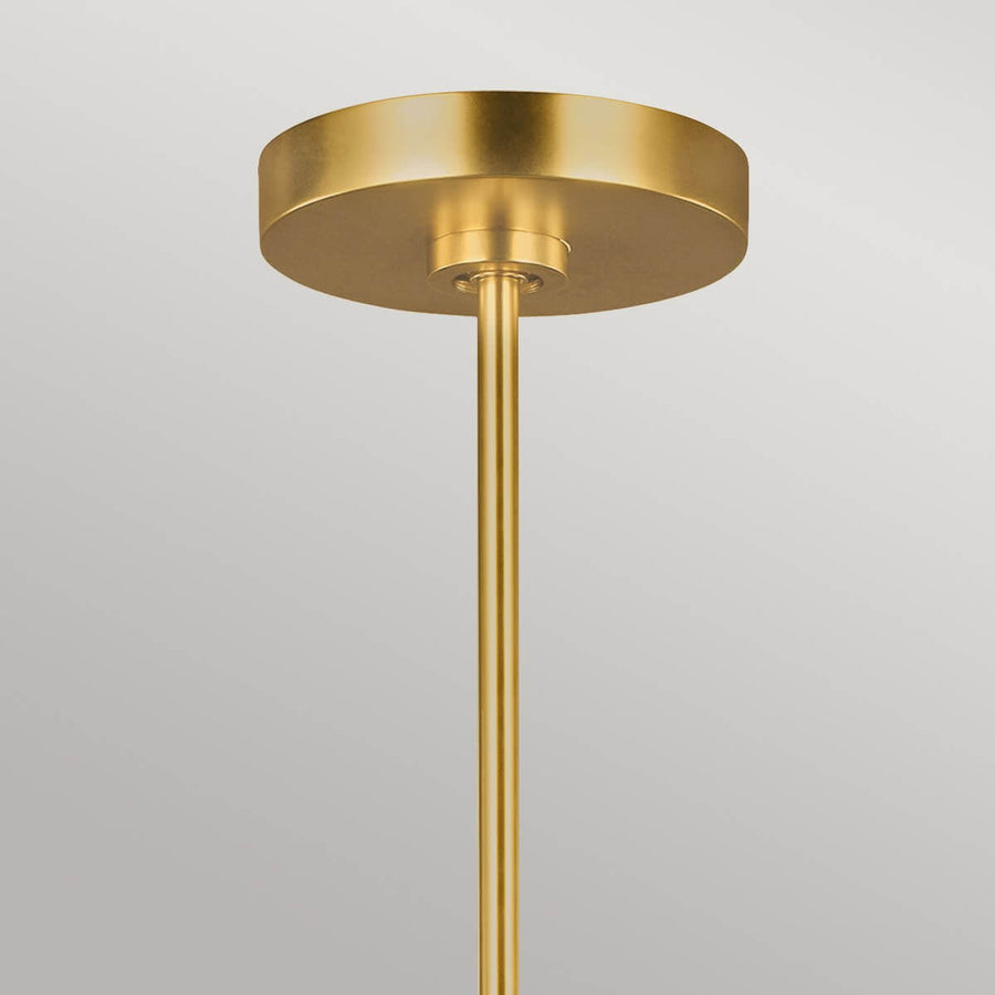 Détail de la rosace ronde en laiton fixée au plafond avec la tige verticale.