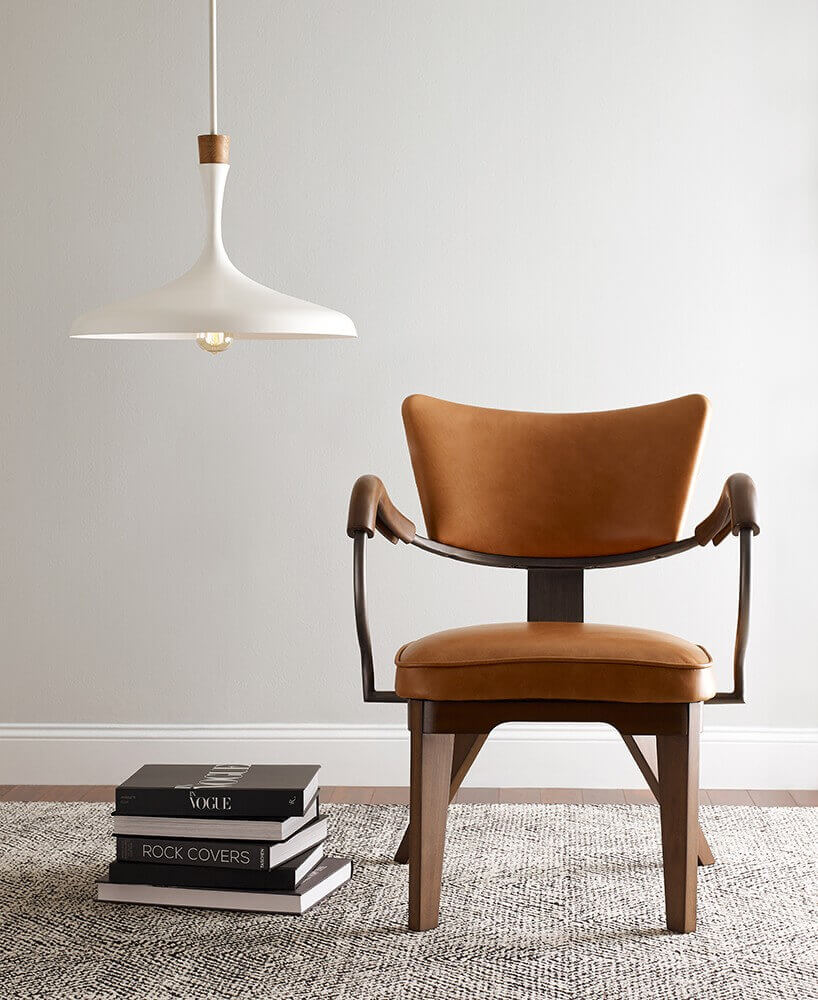 Mise en ambiance du luminaire suspendu au-dessus d'un fauteuil en cuir camel