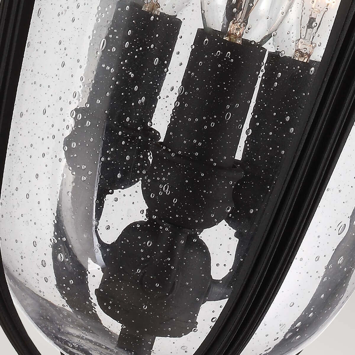 Vue rapprochée des trois douilles noires et ampoules sous verre moucheté