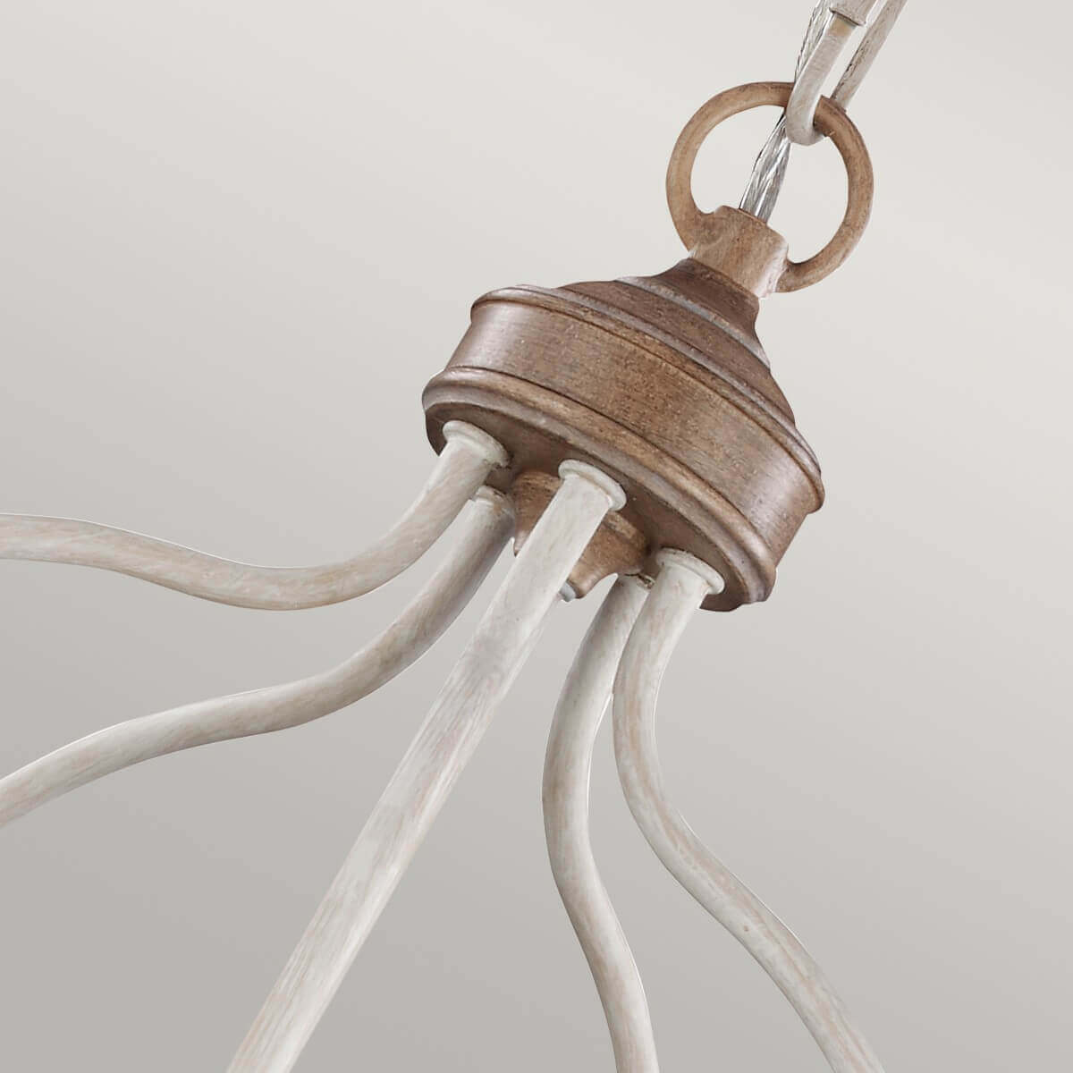 Gros plan sur le raccord supérieur en bois et les bras courbes blancs du luminaire.