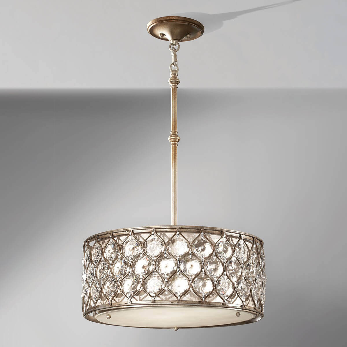 Vue de face sur fond gris, luminaire suspendu avec cristaux et structure métallique.