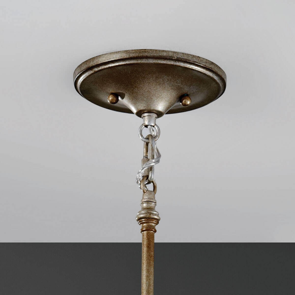 Détail du pavillon rond fixé au plafond, chaîne et raccord métallique patiné.